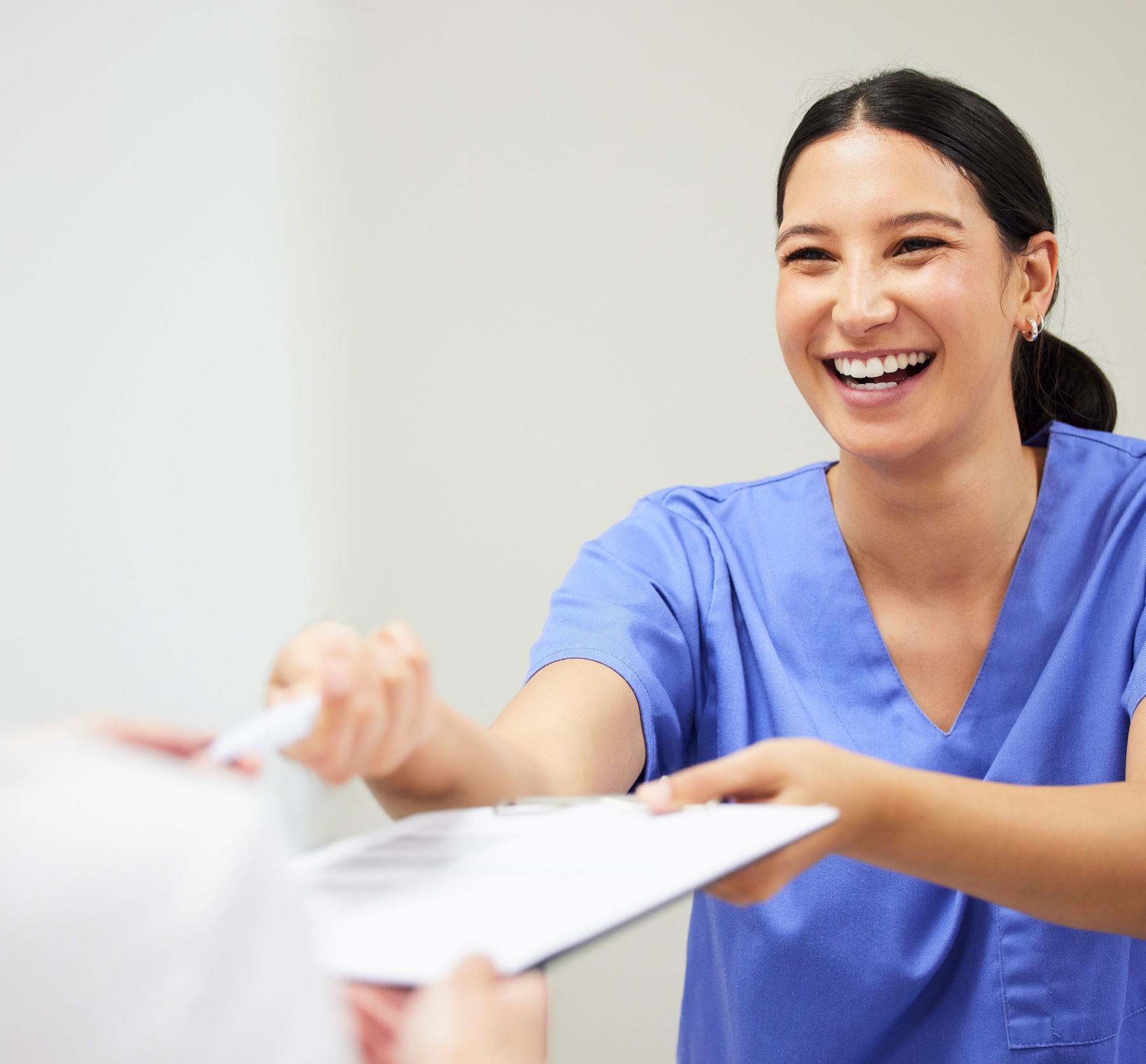 A nurse hands a chart to a patient off camera
