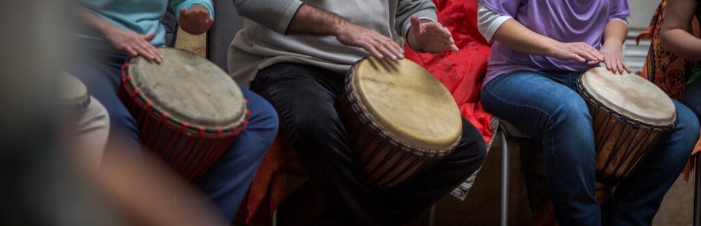 A group of people participate in a music drum therapy session together
