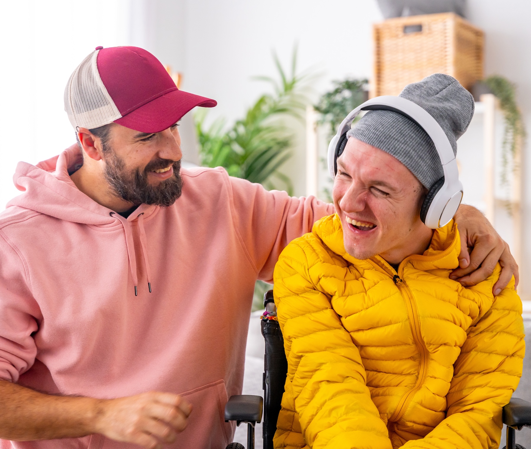 Smiling disabled man and caregiver during art therapy session with music.